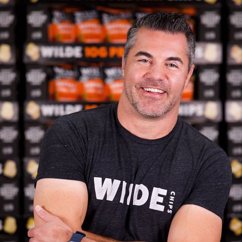 Wilde Protein Chips Founder Jason smiling while wearing a Wilde branded T-shirt.